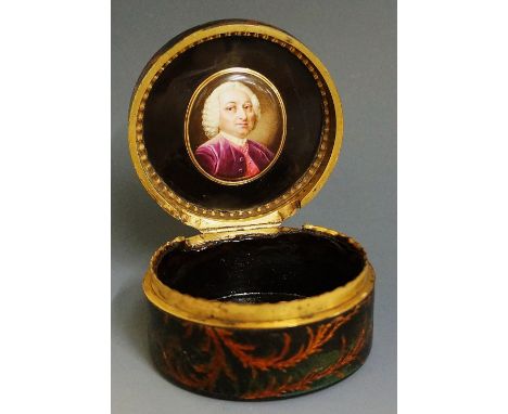 A 19th Century green papier maché circular box the hinged lid decorated with musical trophy and leafage the body and base con