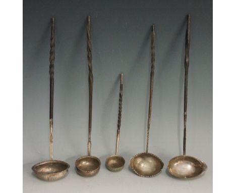 A collection of five toddy ladles, all with baleen twist handles, variously designed silver coloured metal bowls, one engrave