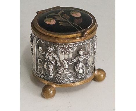 A 19th Century patch box, the drum form body chased and engraved with figures carousing and dancing within a tavern, the glas