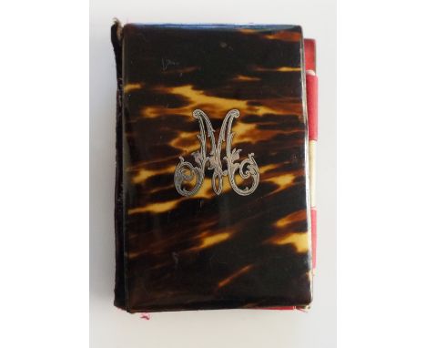 A 19th Century tortoiseshell aide memoire the front inlaid with an  engraved silver initial M, the pink silk interior with pa