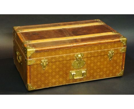 A French brass bound leather and fabric trunk, the hinged top with brass bound corners, pair of wooden studded rails, the fro