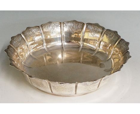 A silver dish, the petal form scalloped sides chased with a repeating scroll motif, raised circular foot, by D & J Wellby Ltd