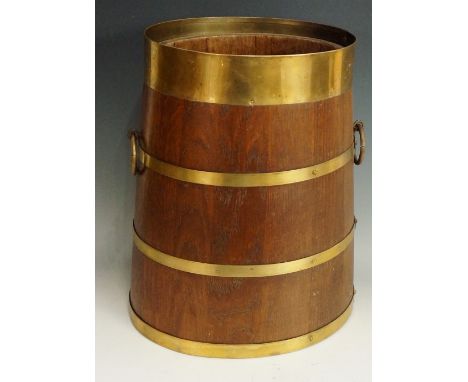 An oak stick stand of tapered oval form with brass coopered bands and pair of ring carrying handles, 36cm high, early 20th Ce
