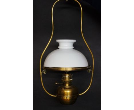 A Victorian brass framed hanging oil lamp with opaque white glass shade, the reservoir seated within the base ring, 70cm high