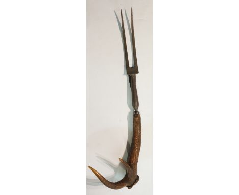 An unusual mammoth stag's antler handled carving fork, 77cm long, Circa 1860