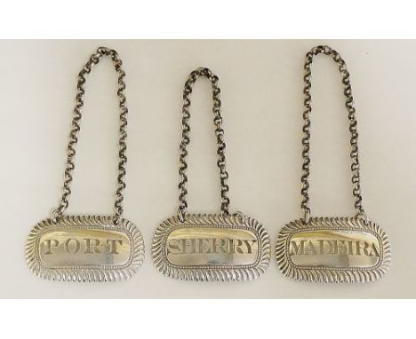 A set of three George III decanter labels, each with oblong body, gadrooned rims and pierced to the centres with 'Madeira', '