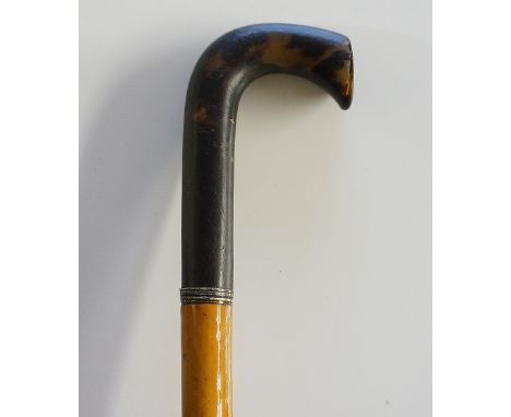 A 19th Century walking stick, the short L shaped handle carved of seamed tortoiseshell, narrow reeded collar, malacca shaft, 
