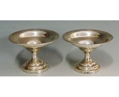 A pair of small silver dishes, the plain bowls with folded over rims, stepped circular pedestal feet, weighted, by Barker Bro