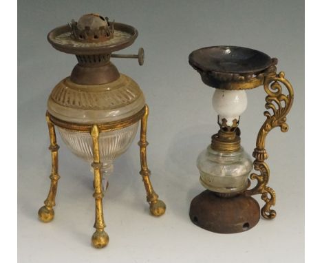 A Victorian cut glass oil lamp of urnular form with faceted pendant base, contained within a gilt metal four legged stand, 19