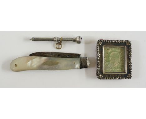 A miniature silver frame the border embossed with flowerheads and pendants, 3.4cm high; a Victorian silver toothpick with ame