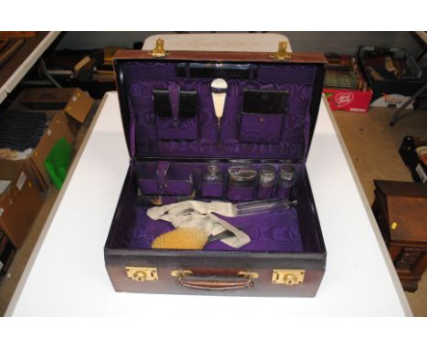 A vanity case and contents of silver backed brushes, jars, combs, manicure items etc.