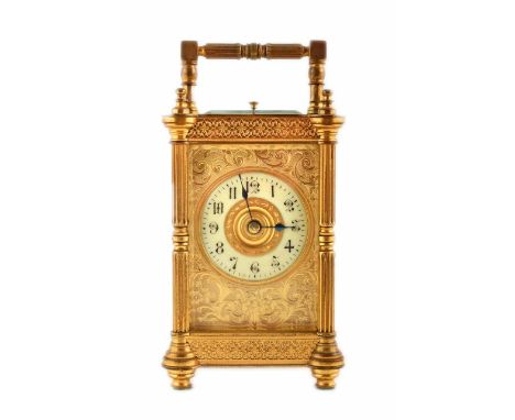 A 19th century brass carriage clock. With fluted doric columns, brass fretwork and engraved foliate design framing an enamel 