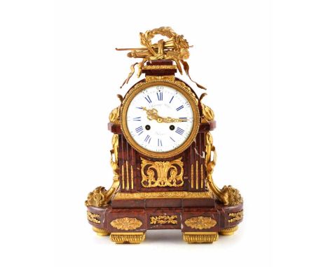 A 19th century French rouge marble mantel clock by Raingo Freres. The rouge marble case is embellished with cast brass whimsi