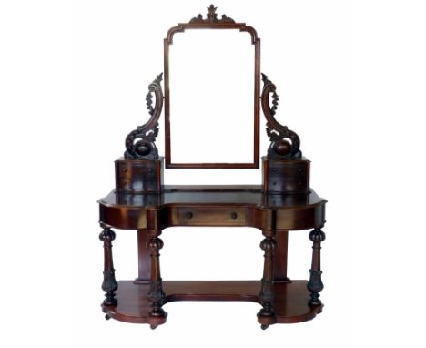 Victorian mahogany dressing table, the arched framed mirror supported on two carved and moulded brackets with two small bowed