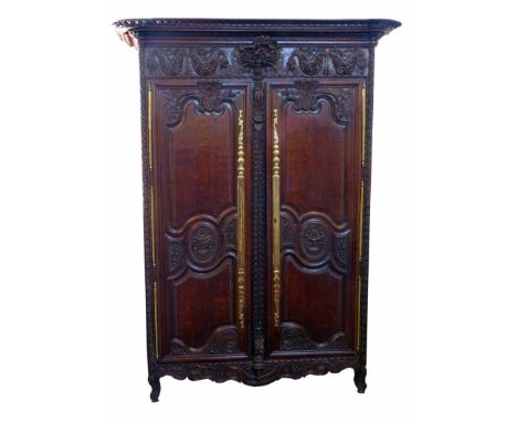 Early 19th century French carved oak armoire, heavily carved all over with swags of flowers, fitted two doors with shaped pan