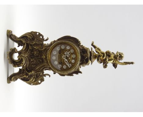French style cast gilt metal cartouche shaped mantel clock, putto finial above circular dial with Roman numerals, scrolled fo