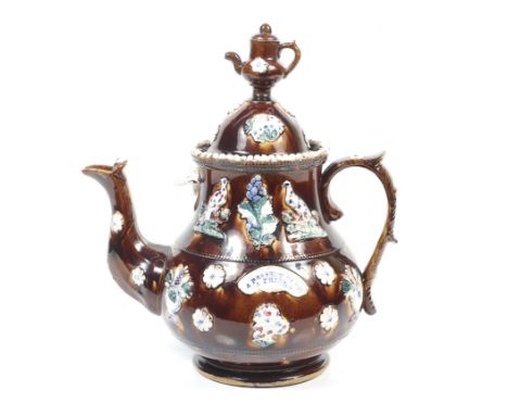 A Victorian bargeware teapot. The domed cover topped with a teapot finial, the baluster body inscribed 'A PRESENT FROM A FRIE