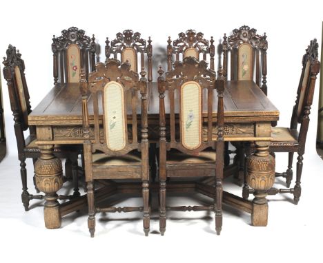 A 20th century, Charles II style extendable table and eight Victorian Jacobean style chairs. The table carved with fruting vi