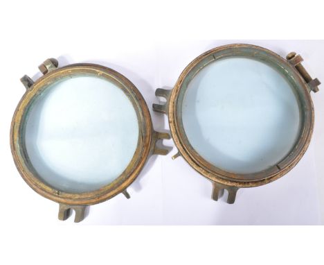 A pair of early 20th Century believed WWI First World War period ship porthole windows. Sold bronze outer rim with hinged edg