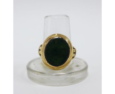Vintage yellow metal ring inset with an oval bloodstone plaque, unmarked, UK ring approx 4.7g