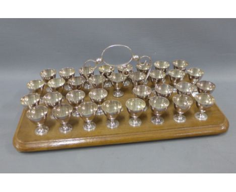 Collection of Epns shot cups on a wooden tray style base, 33 cups in total with one missing, 52cm long  