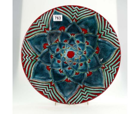 Poole pottery Studio pottery charger decorated in blue, red & green flower heads signed N Massarella , diameter 42cm