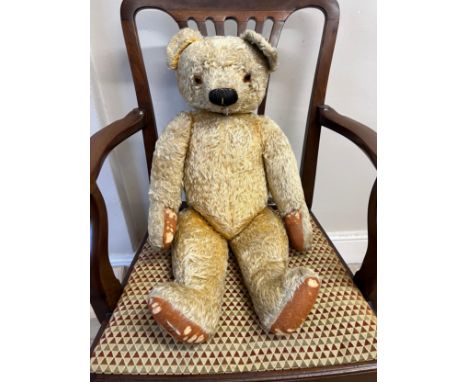 A Chad Valley 1940’s Teddy Bear with golden curly mohair, deep amber and black glass eyes, black stitched button nose and mou