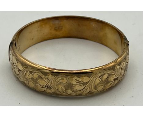 A 9 carat yellow gold bangle, engraved to one side. Weight 18gm. 