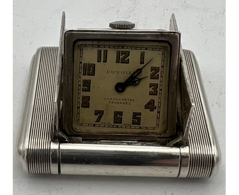 An Art Deco Dunhill silver miniature travel clock, engine turned case with hinged divided doors enclosing the hinged clock,  