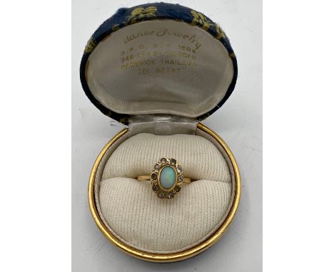 An 18 carat gold ring set with opal and clear stones. Size J. Weight 2.9gm. 