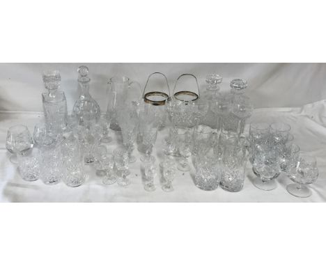 A large quantity of cut glass to include four decanters, two ice buckets with handles, large jug 22cm h, 4 brandy glasses, 4 