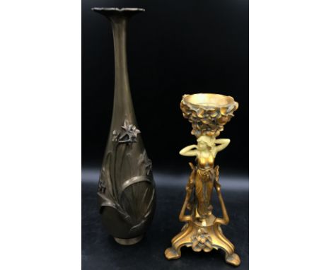 A large heavy metal vase decorated in flowers with oriental writing inscribed to base along with a art deco style candlestick