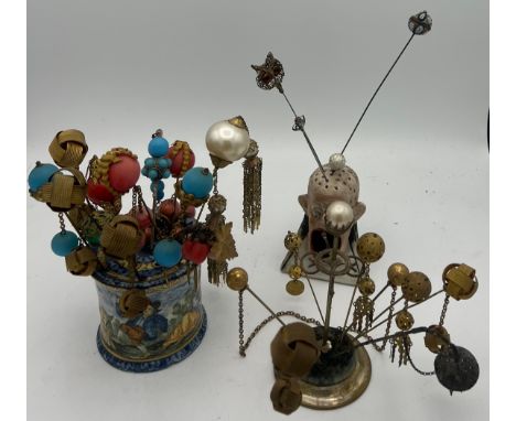 A quantity of 19th and early 20thC hat pins and hair ornaments together with majolica and bisque hatpin holders.  The pins to