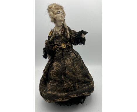 A 19thC doll with bisque heads and arms on a weighted base. 32cm h. 