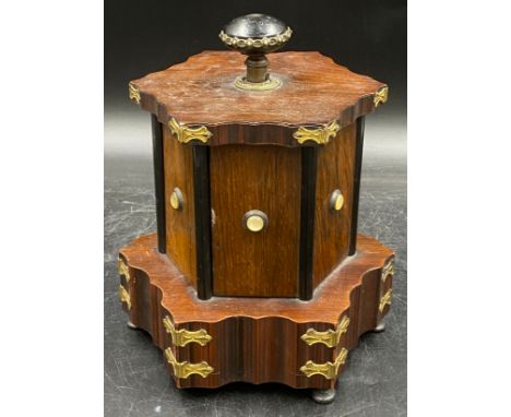 A musical box/sewing companion, hexagonally shaped with ebonised, gilt and shell embellishments on raised feet. Six doors, 4 