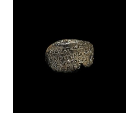 3rd-1st century BC. A grey ceramic token (symbolon) with a roughly oval-shaped face bearing four lines of Greek text: 'for th