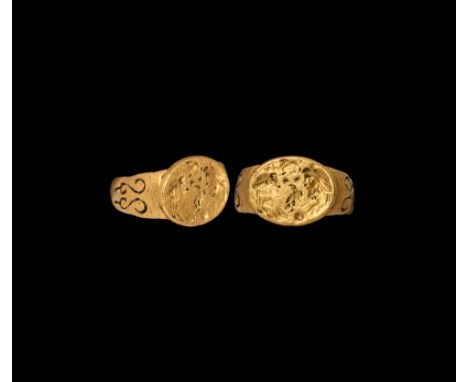 1st century AD. A substantial gold ring with wide semi-circular hoop, expanding shoulders with a pair of openwork volute scro