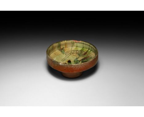 12th-early 13th century AD. A ceramic footed bowl with carinated body, inner face with incised lines below the rim, green gla