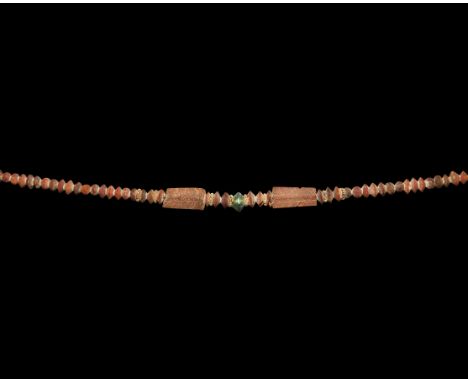 7th century BC. A substantial restrung necklace of amber beads, mainly biconvex and spherical types, with eight gold filigree