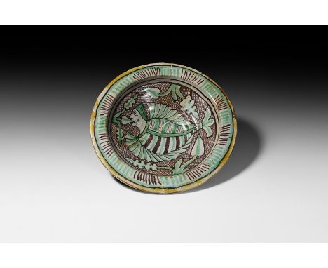 15th-16th century AD. A ceramic maiolica bowl with carination and ribbing to the underside, broad flange rim with radiating p