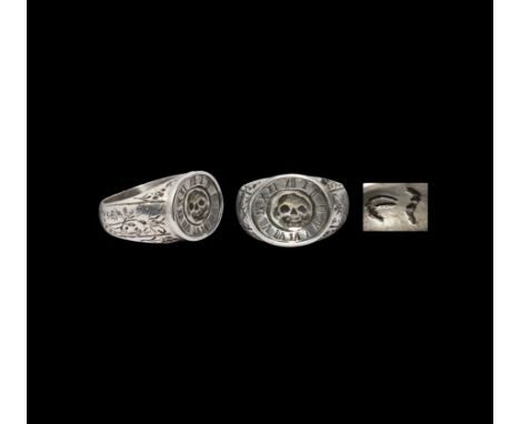 18th century AD. A silver memento mori finger ring with broad hoop and ellipsoid bezel; the hoop with bands of flowers, leave