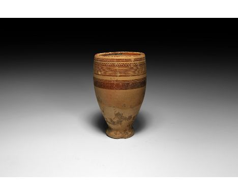 6th-1st century BC. A ceramic piriform vase or cup with inverted rim and discoid foot; the upper body painted with circumfere