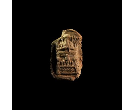 20th-16th century BC. A ceramic sub-rectangular plaque with moulded high-relief image of a facing bearded male with broad cap