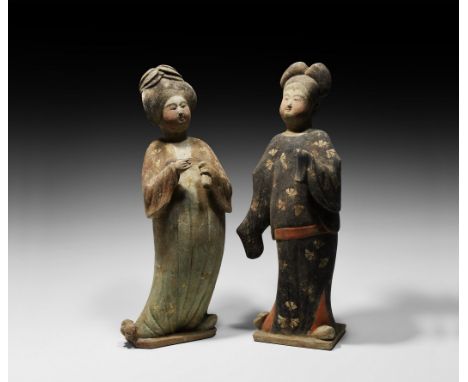 Tang Dynasty, 618-907 AD. A pair of hollow-formed ceramic figures modelled as courtly ladies standing on integral polygonal b