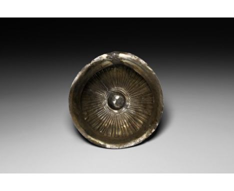 6th-4th century BC. A silver discoid bowl with flared rim and prominent raised central boss surrounded by circles; at the ext