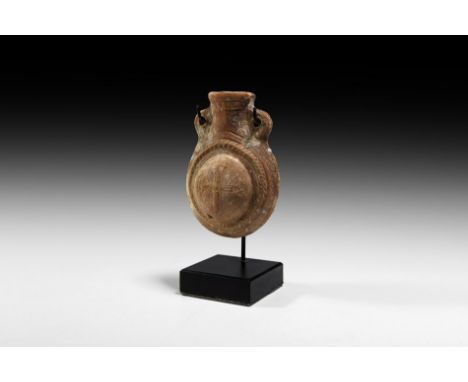 10th-12th century AD. A terracotta flask with rounded body and wide mouth flanked by pierced lugs to the shoulders; band of r