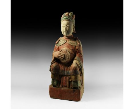 Late Ming Dynasty, 1368-1644 AD. A substantial hollow-formed ceramic statue formed as a seated figure holding an oval disk ag