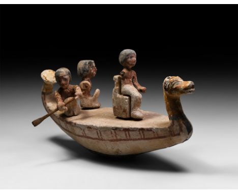 Middle Kingdom, 2133-1797 BC. A gesso-painted wooden funerary model boat with animal-headed bow, manned by two oarsmen with a