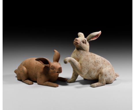 Tang Dynasty, 618-907 AD. A pair of life-size ceramic rabbit figures, one modelled in a crouching position, one seated with o