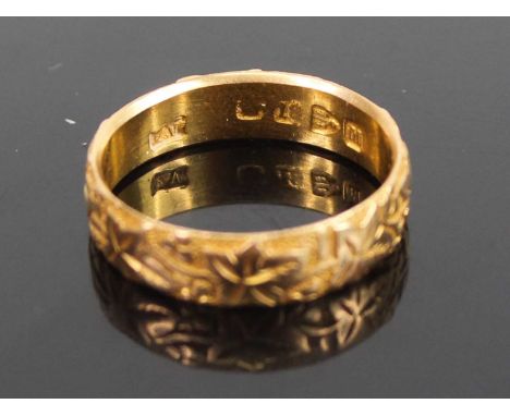 An 18ct gold and engraved wedding band, 3.8g, sponsor EV?, size NMarks a bit rubbed,light scratches. Chester 1895.